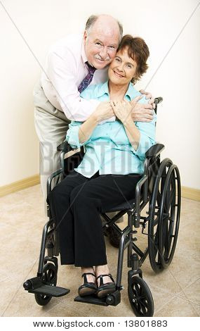 Loving middle-aged husband and wife.  She is in a wheelchair.