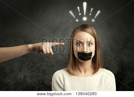Caucasian hand pointing at female employee with drawn exclamation marks above her head