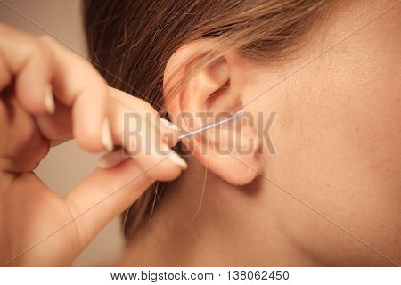 Woman Cleaning Ear With Cotton Swabs Closeup