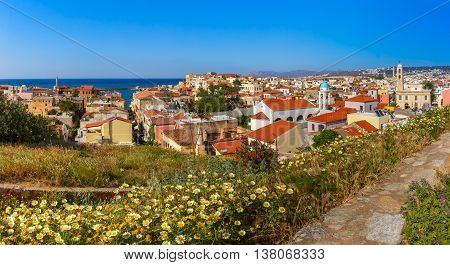 The medieval city with Orthodox cathedral Trimartiry and lighthouse in old harbour, panoramic aerial view from Schiavo Bastion in the sunny morning, Crete, Greece