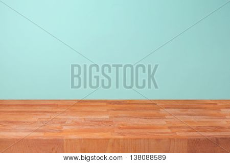 Empty wooden kitchen counter over mint wall background for product montage display