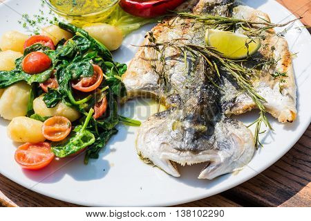 Fresh fish sea bream bream with salt herbs and pepper prepares grilled.