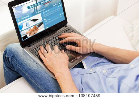 technology, people, mass media and lifestyle concept - close up of male hands typing on laptop computer with business news web site on screen at home