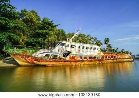 Labuan,Malaysia-July 12,2016: Abandoned broken ferry ship wreck known as Duta Muhibbah Dua beached on sea shore at Labuan island,Malaysia on 12th July 2016.