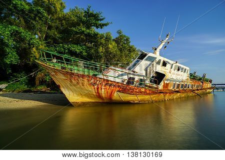 Labuan,Malaysia-July 12,2016: Abandoned broken ferry ship wreck known as Duta Muhibbah Dua beached on sea shore at Labuan island,Malaysia on 12th July 2016.