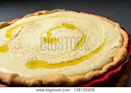 Close-up photo of tart with cream and olive oil, prepared for baking, selective focus