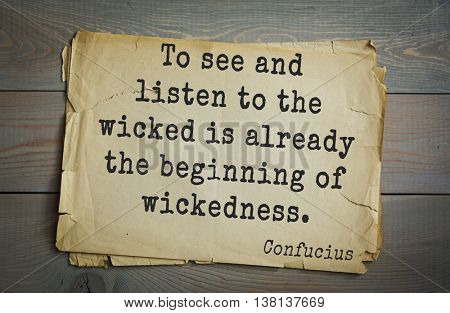 Ancient chinese philosopher Confucius quote on old paper background. To see and listen to the wicked is already the beginning of wickedness.