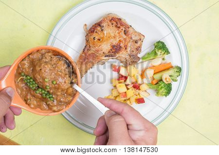 Chef puted gravy sauce to pork chop steak / cooking porkchop steak concept