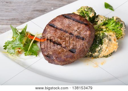 Fried beef cutlet served with broccoli garnish