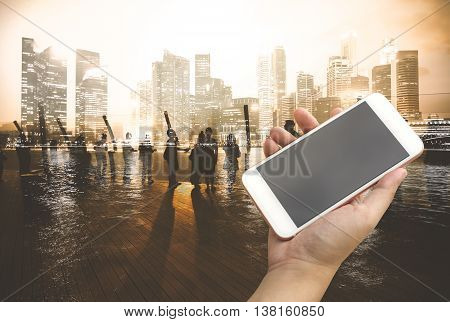 Hand Holding Smartphone With City People