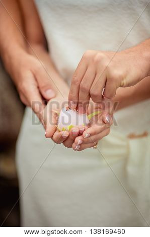Wedding flower with rings in bride hands with white dress