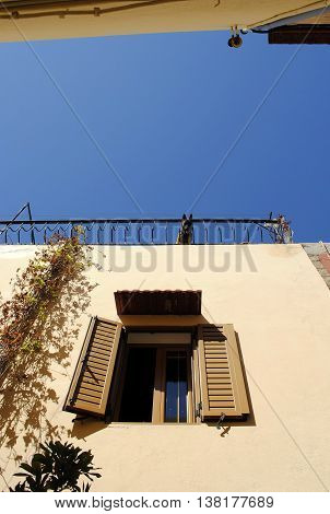 Dog on the roof and a window with shutters