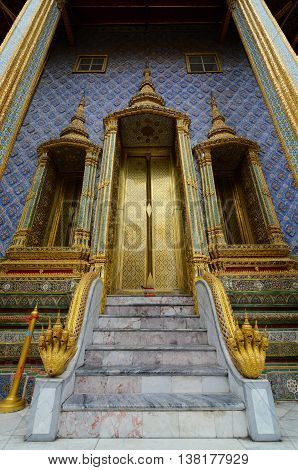 Bangkok, Thailand - June 30, 2016: Beautiful golden doors and naga serpents at the entrance to the Phra Mondop library at Thailand's Grand Palace