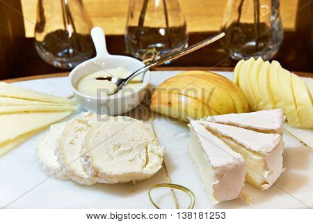 Cheese Plate With Camembert, Buche, Apple And Honey On Table