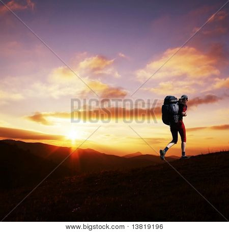 Ragazza andando lungo la collina sul tramonto
