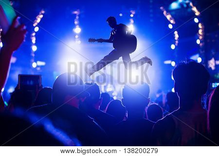Singer singing on concert stage with ray of illuminated, Singer and guitar on stage