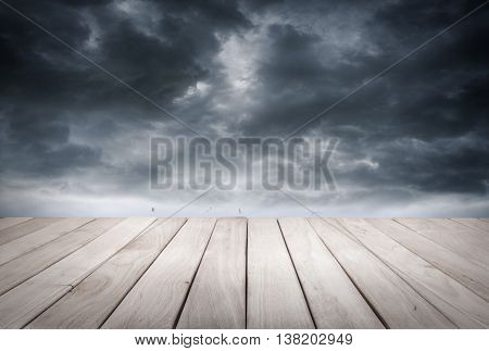 Empty wooden platform and dark stormy sky and stormy sea waves.