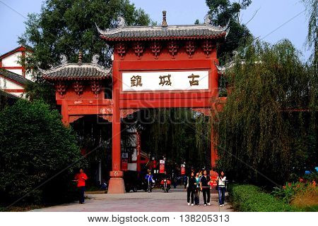 Pixian China - November 10 2007: A large wooden ceremonial entrance gate with flying eaved tiled roofs leads into the town's principle street