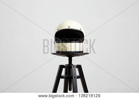 classic motorbike fullface helmet, blank, ivory, isolated on white on black luxury presentation chair, frontside