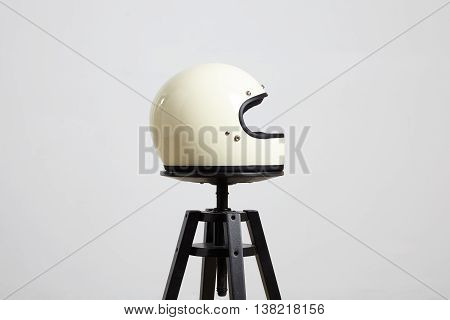 classic motorbike fullface helmet, blank, ivory, isolated on white on black luxury presentation chair, right side