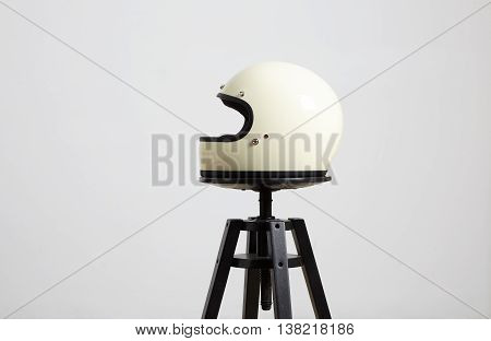 classic motorbike fullface helmet, blank, ivory, isolated on white on black luxury presentation chair, left side