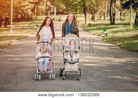 young mother walking with her baby and carries it in a beautiful pram