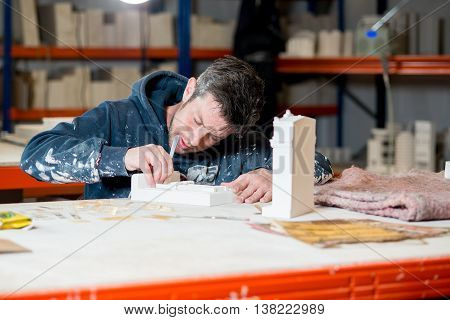 Man Sculpting Plaster Model Buildings