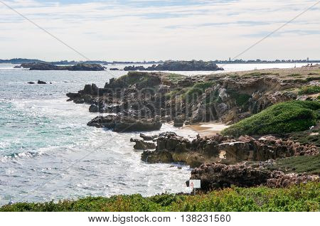 Rugged limestone coast with the Indian Ocean waters under an overcast sky at Penguin Island in Rockingham, Western Australia.