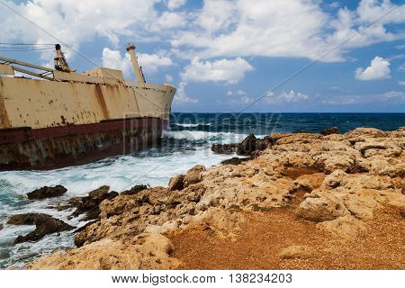 Seascape: boat shipwrecked near the rocky shore. Mediterranean near Paphos. Cyprus