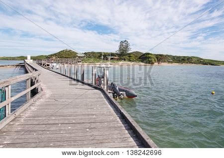 ROCKINGHAM,WA,AUSTRALIA-JUNE 3,2016:  Tourists and jetty entrance to Penguin Island with boats and vegetated dunes along the Indian Ocean coast in Rockingham, Western Australia.