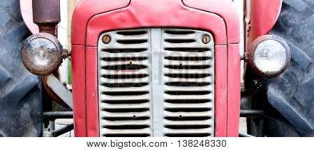 Old tractor face red rusty an dented