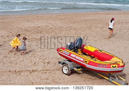 DURBAN SOUTH AFRICA - JULY 09 2016: Children playing on the beach near a surf rescue boat in Umhlanga Rocks