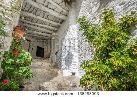 Wide angle view of street and house entrance with plantpots in Capileira, Granada, Spain