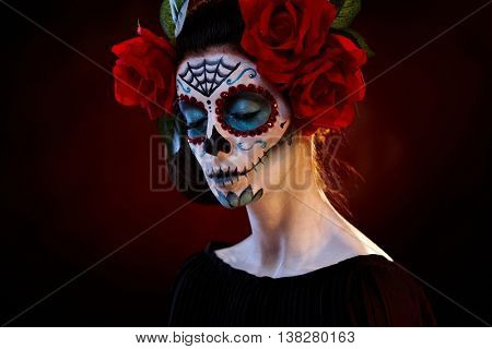Female portrait in mexican santa muerte mask eyes closed.