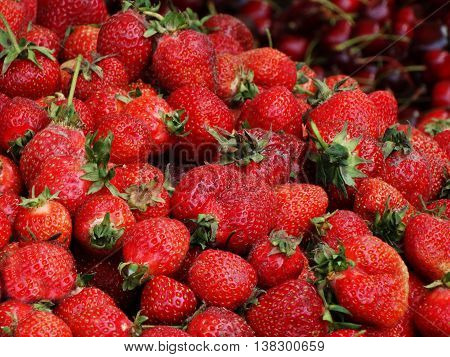 red strawberry lying in a pile on the counter market
