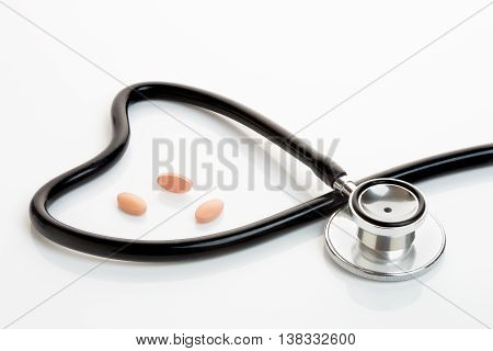 Statin or generic tablets with stethoscope making a heart shape.