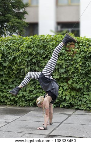 Girl dancing in the city. The choreographic etude on the pavement. Break-dance