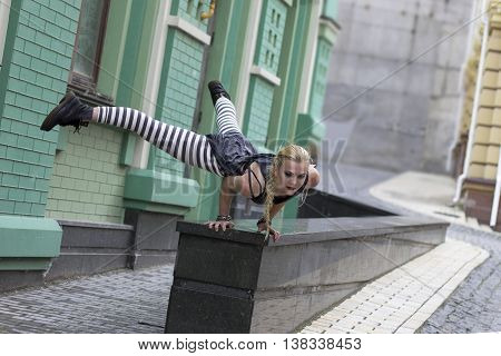 Girl dancing in the city. The choreographic etude on the pavement. Break-dance
