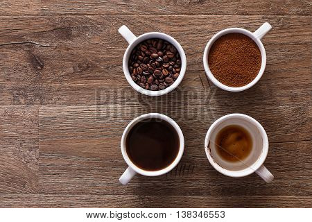 Four cups of coffee, phases of drink - bean, ground and empty cup.