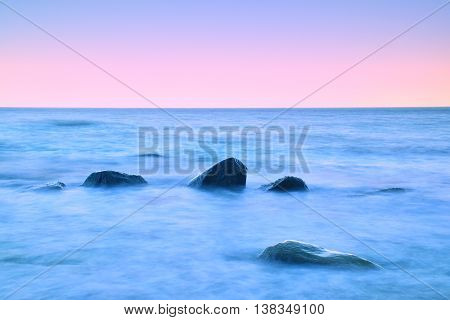 Romantic Morning At Sea. Big Boulders Sticking Out From Smooth Water Level. Pink Horozon With First