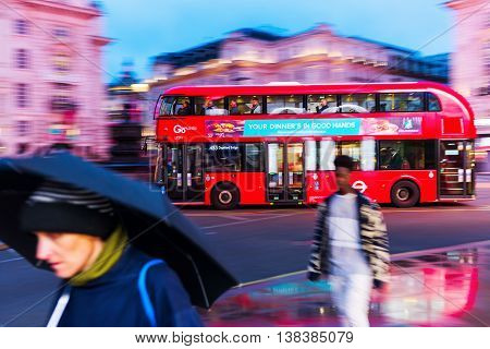 Red Double Decker Bus In Motion Blur At Piccadilly Circus In London, Uk, At Night