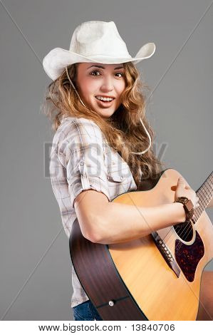 Sesy vaquera en el sombrero de vaquero con guitarra acústica
