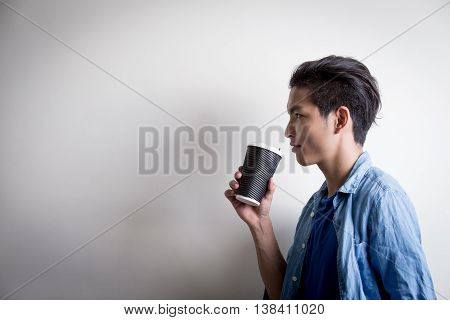 man is drinking coffe and looking somewhere isolated white background asian
