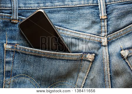 Mobile phone in back pocket faded jeans