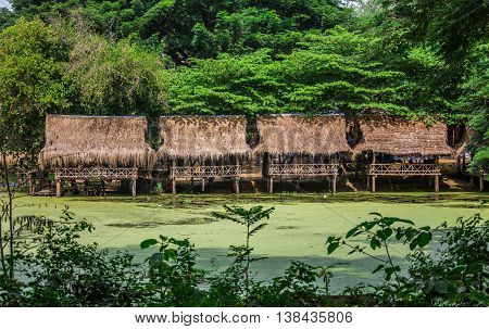 Nipa bamboo Huts at the White Sand beach with palm trees in Raja Ampat, Papua New Guinea, Indonesia