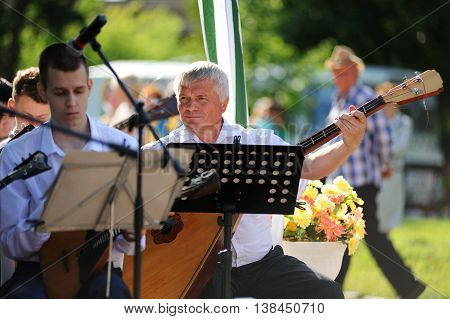 Orel Russia - July 08 2016: Russian Valentine Day - Petr and Fevronia. Senior man playing bass-balalayka selective focus