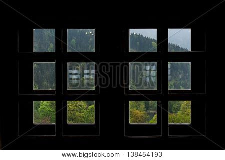 View of Austrian Woods in Tirol through Silhouetted Small Square Windows