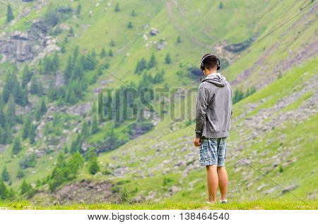 Teenager man with headphones watching the mountains melacholic