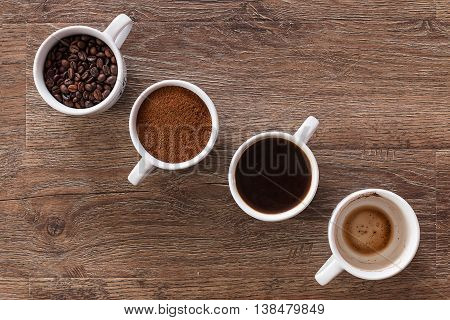 Four cups of coffee, phases of drink - bean, ground and empty cup