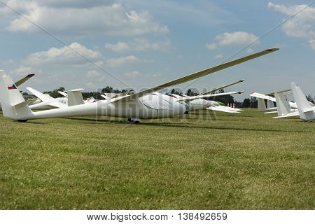 gliders at green airfield with blue sky in sunny day